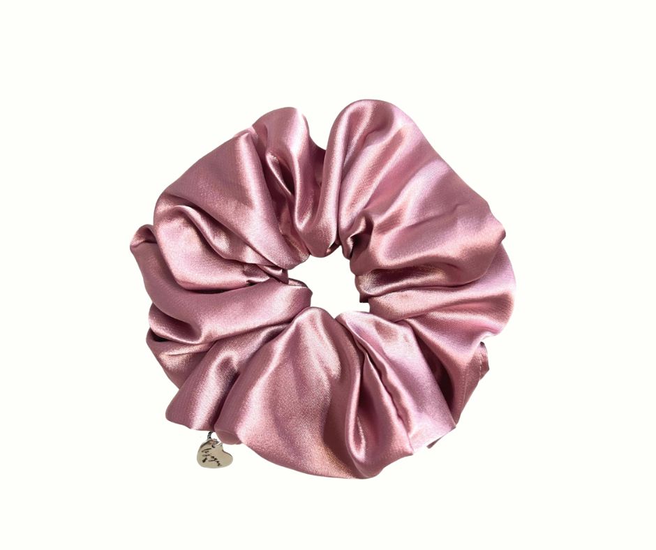 Mauve silk scrunchie with a heart charm on a white background
