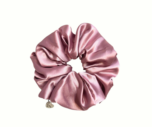 Mauve silk scrunchie with a heart charm on a white background