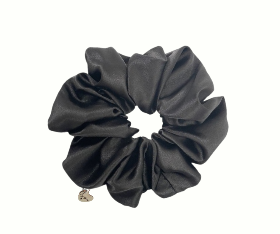 Black scrunchie with a small heart charm on a white background