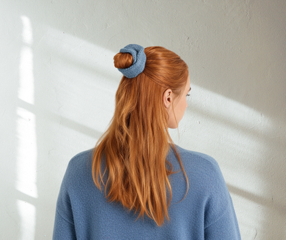 blue knit scrunchie on model with blue knit sweater on light background.