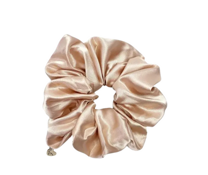 silk scrunchie in champagne color with le joyau charm on white background