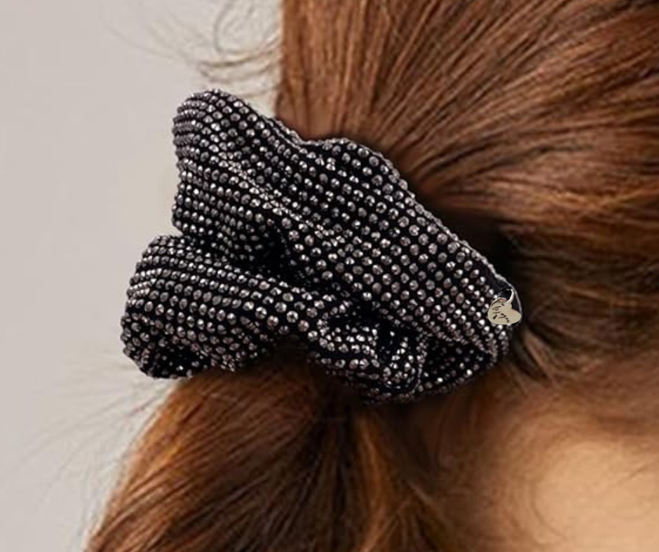 Close-up of black scrunchie with grey rhinestones on model with neutral background