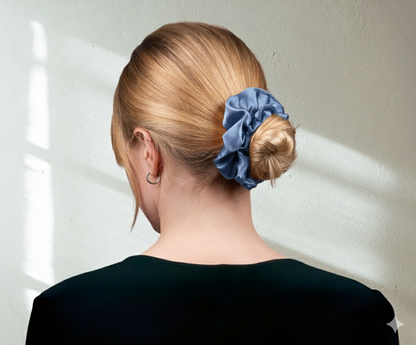 Silk blue scrunchie-on-model-with-black top on light background.